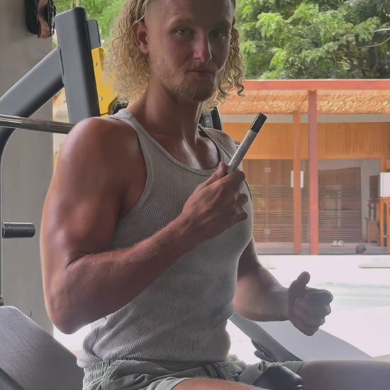 Man using VitaBlue Methylene Blue Nano spray before workout in a gym, promoting focus, energy, and mitochondrial support