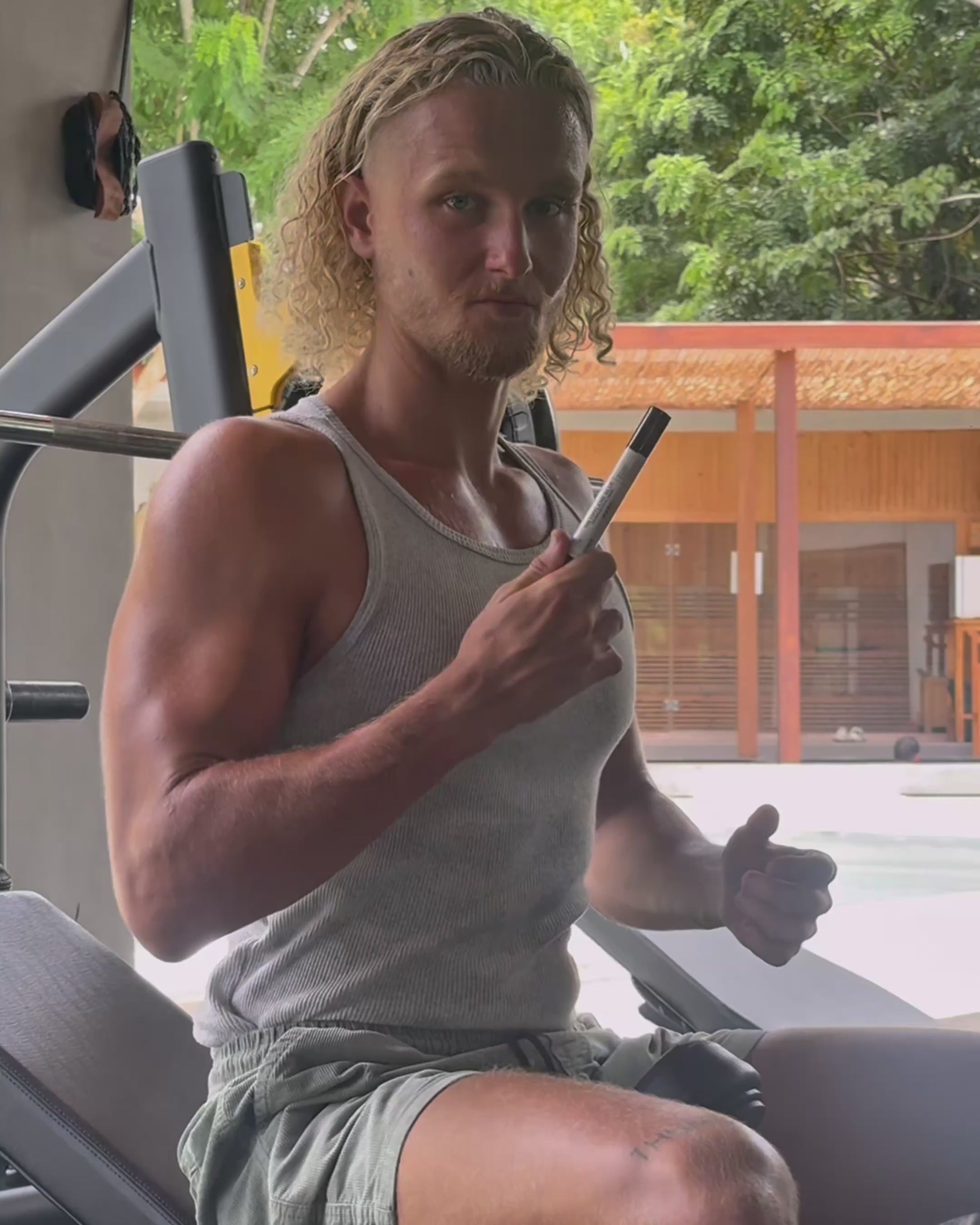 Man using VitaBlue Methylene Blue Nano spray before workout in a gym, promoting focus, energy, and mitochondrial support