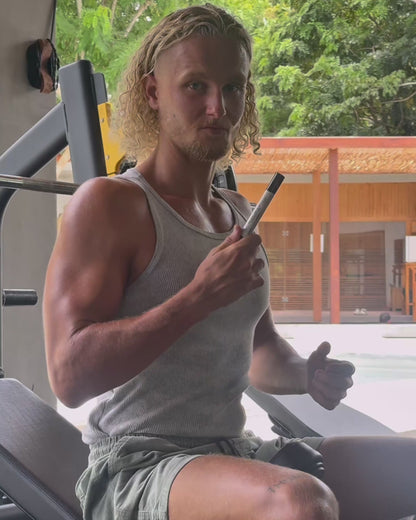 Man using VitaBlue Methylene Blue Nano spray before workout in a gym, promoting focus, energy, and mitochondrial support