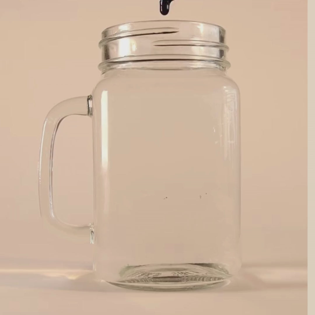 Short video showing a drop of VitaBlue Methylene Blue falling into a clear glass jar of water, demonstrating its vibrant blue dispersion on a beige background